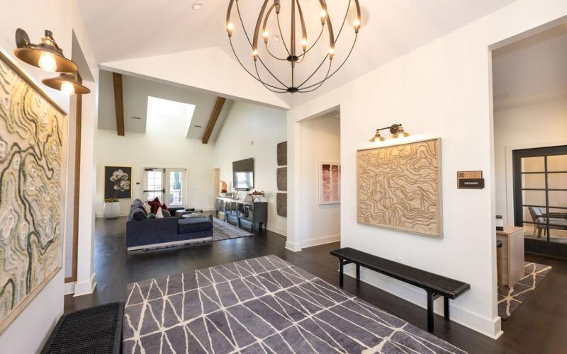 a large living room with a chandelier and a bench