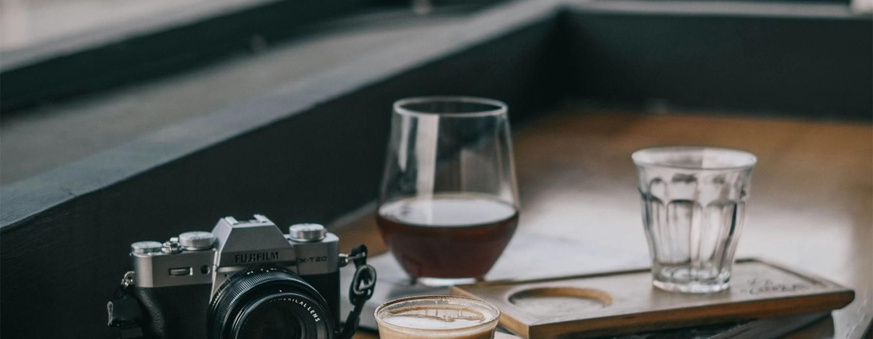 a camera and cup of coffee on a table